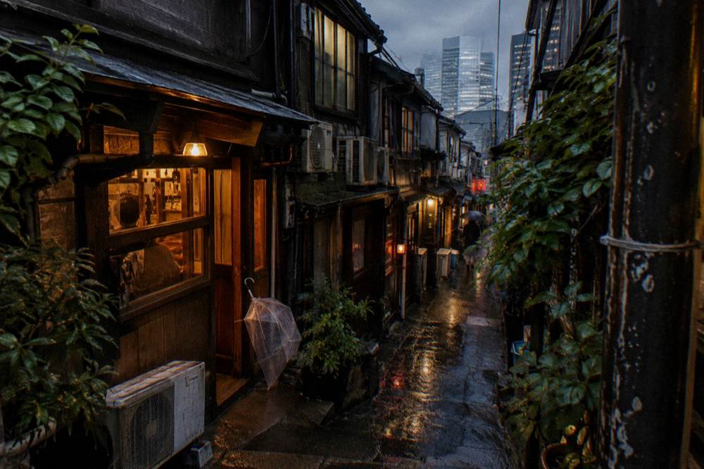 Warm lanterns glowing in the narrow Golden Gai alleys at night