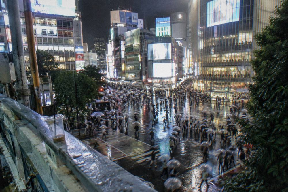 Neon signs and crowded streets around a major Tokyo crossing at night