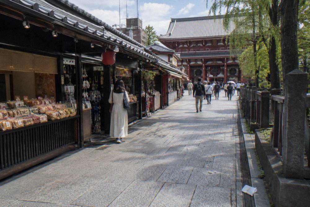 Historic shopping street lined with small snack shops leading to a large temple gate
