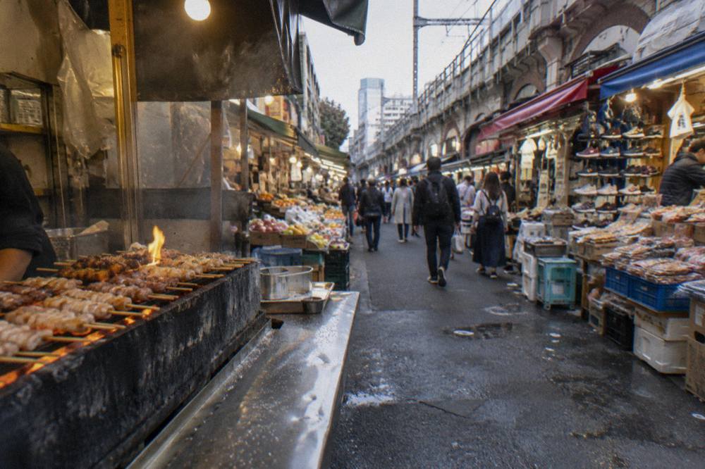 Close view of yakitori skewers grilling over charcoal at a narrow counter