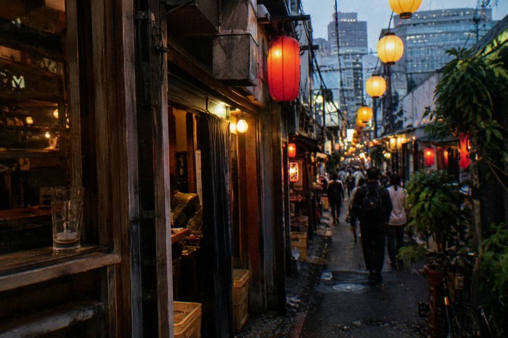 Night street packed with glowing restaurant signs and lanterns over a canal