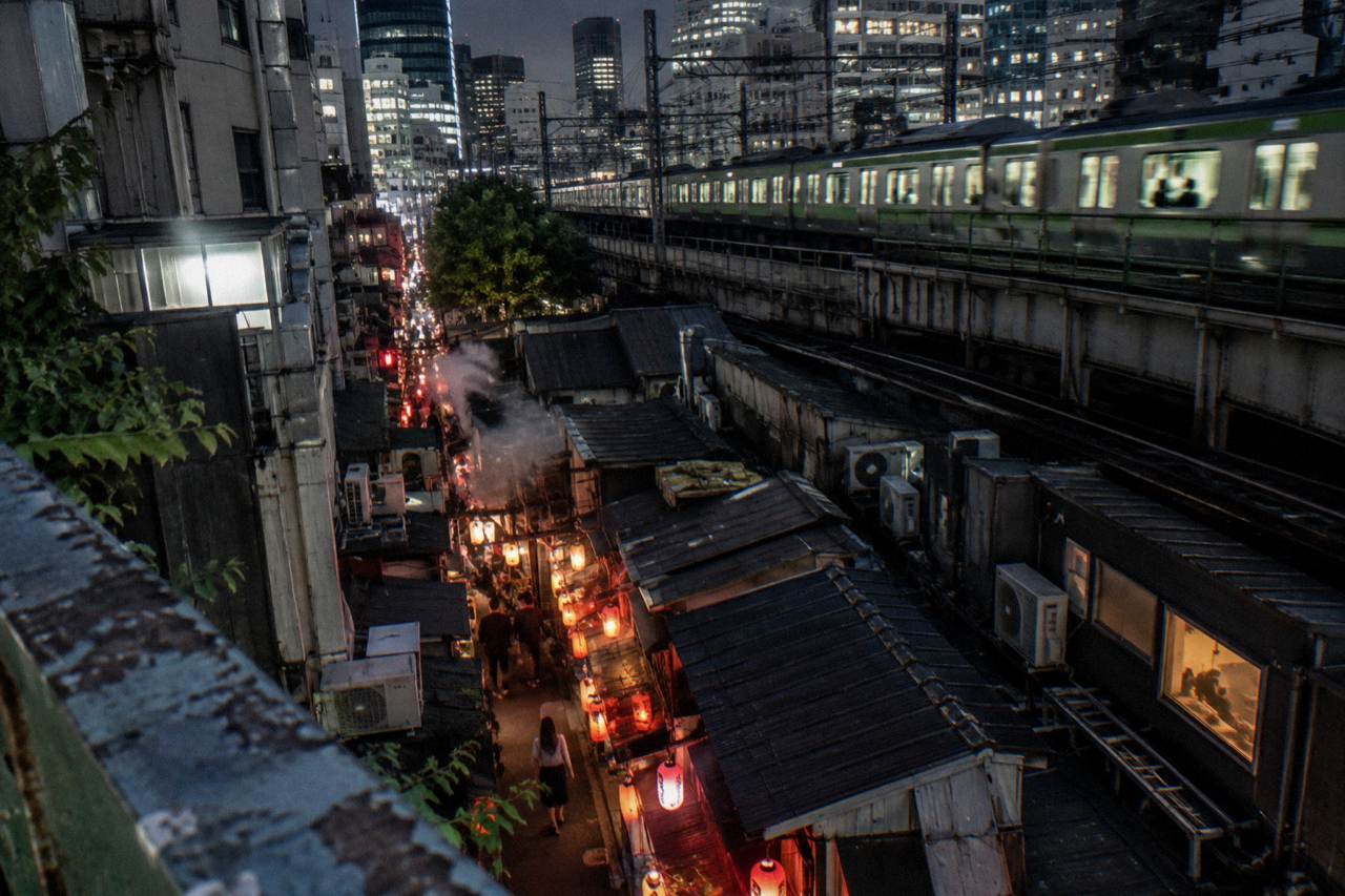 Lantern-lit alley of small yakitori counters in Shinjuku at night