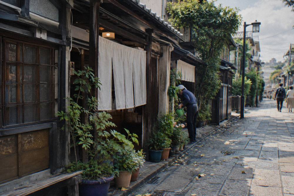Row of ramen shop signs and noren curtains along a Tokyo side street in daylight