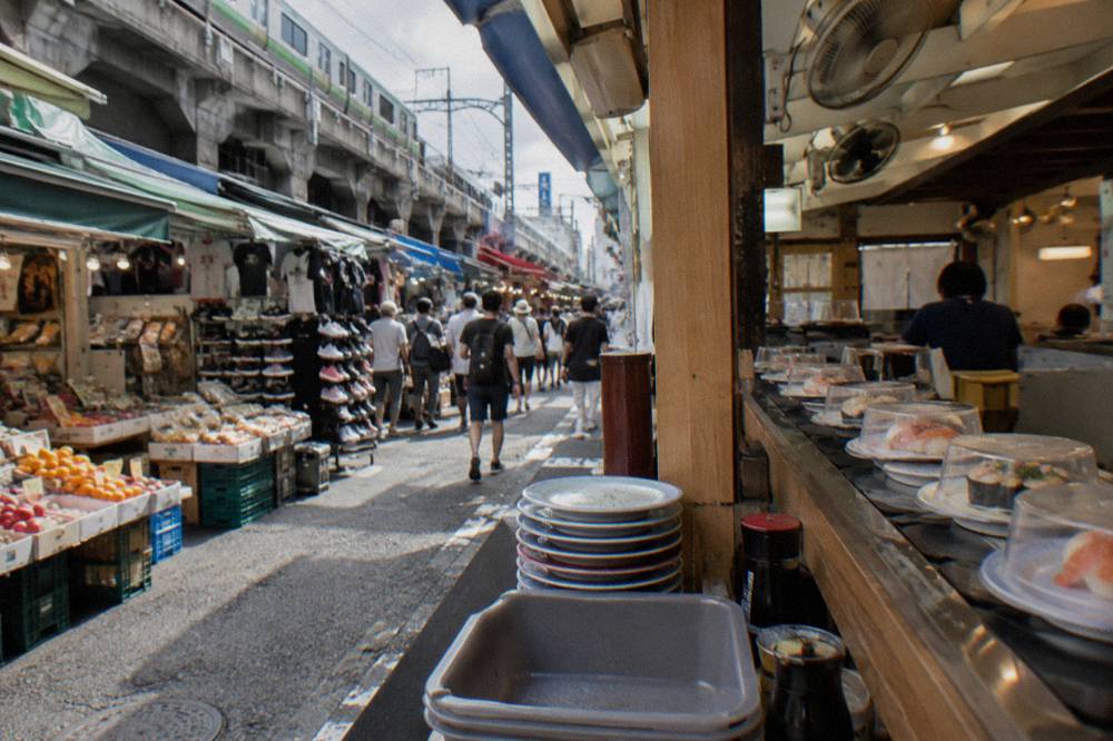 Rows of sushi plates moving along a conveyor belt in a bright casual restaurant