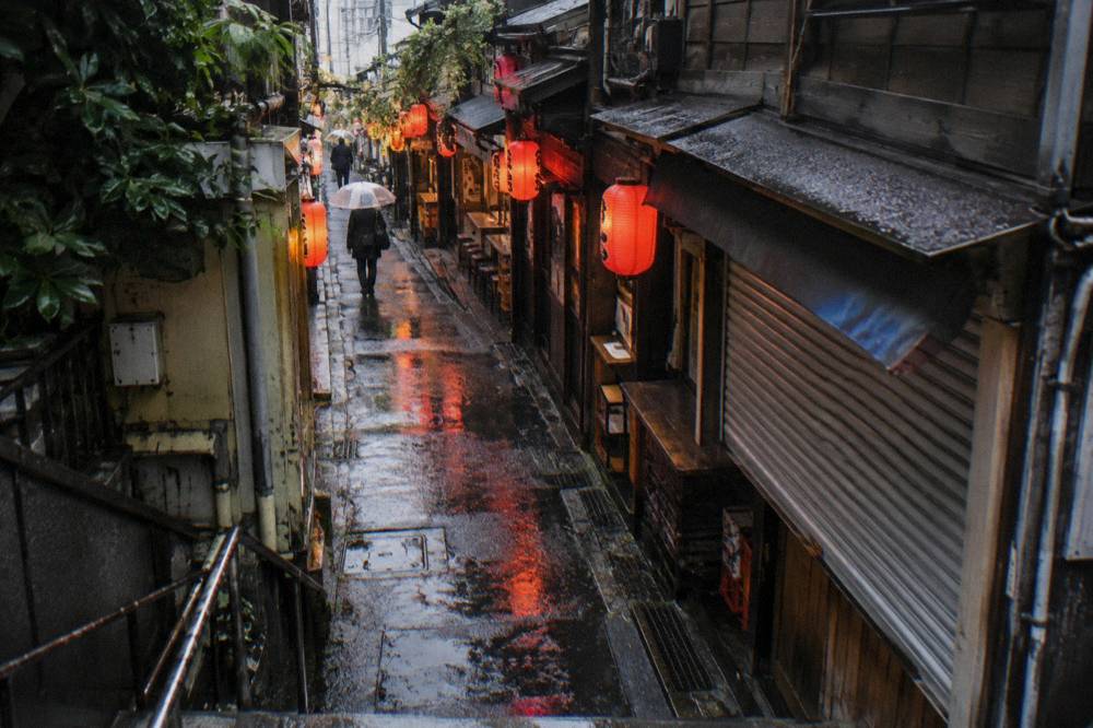 Narrow lantern lit alley of small bars glowing after dark in a Tokyo nightlife district
