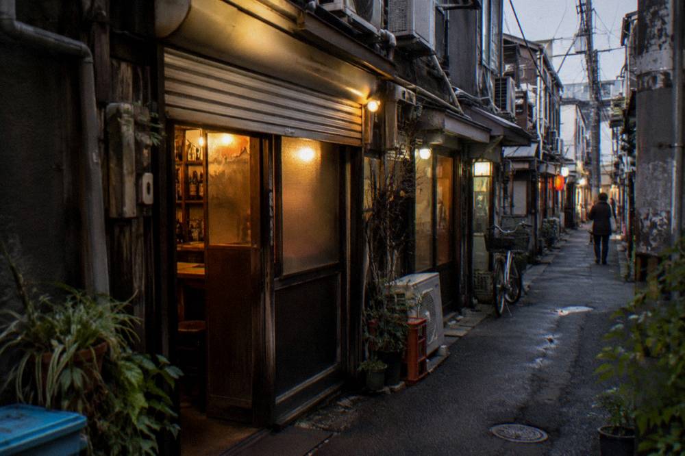 Evening street scene outside Golden Gai with bars beginning to light up