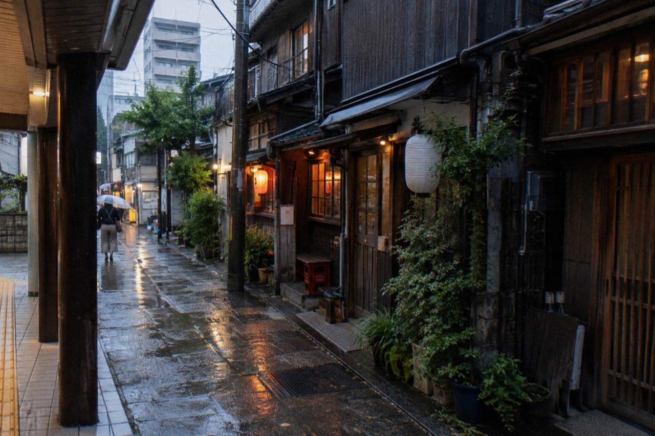 Narrow lantern-lit backstreet alley in a Tokyo neighbourhood at dusk with small bar storefronts