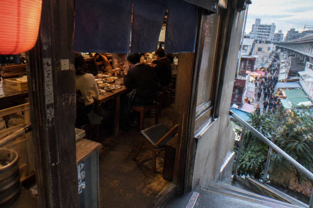 Group of dishes served together on a long wooden table inside a small restaurant