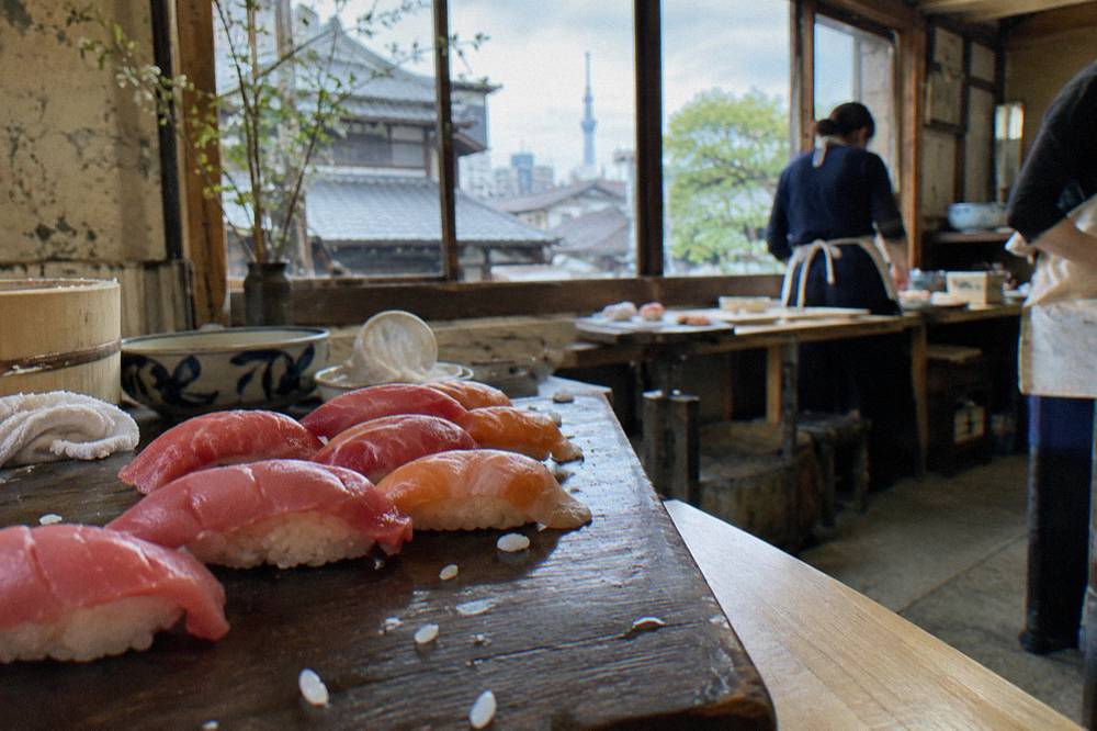 Fresh sushi nigiri arranged on a dark wooden board after a hands-on shaping lesson.