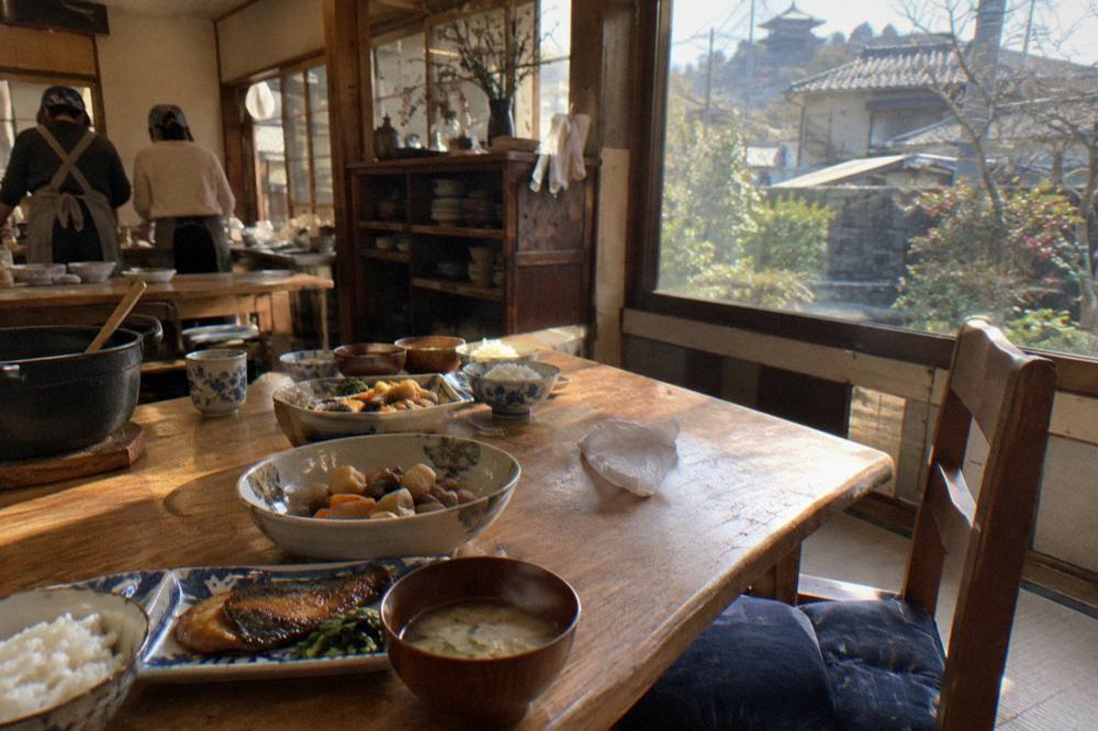 Cooked Japanese dishes served family style on a wooden table at the end of a group cooking class.