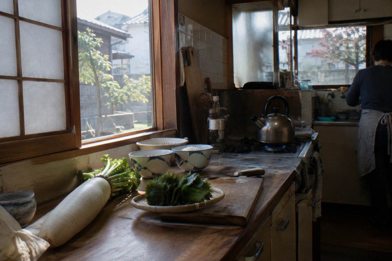 Home kitchen counter in Tokyo set with cutting boards, fresh vegetables and rice bowls ready for a hands-on cooking session.