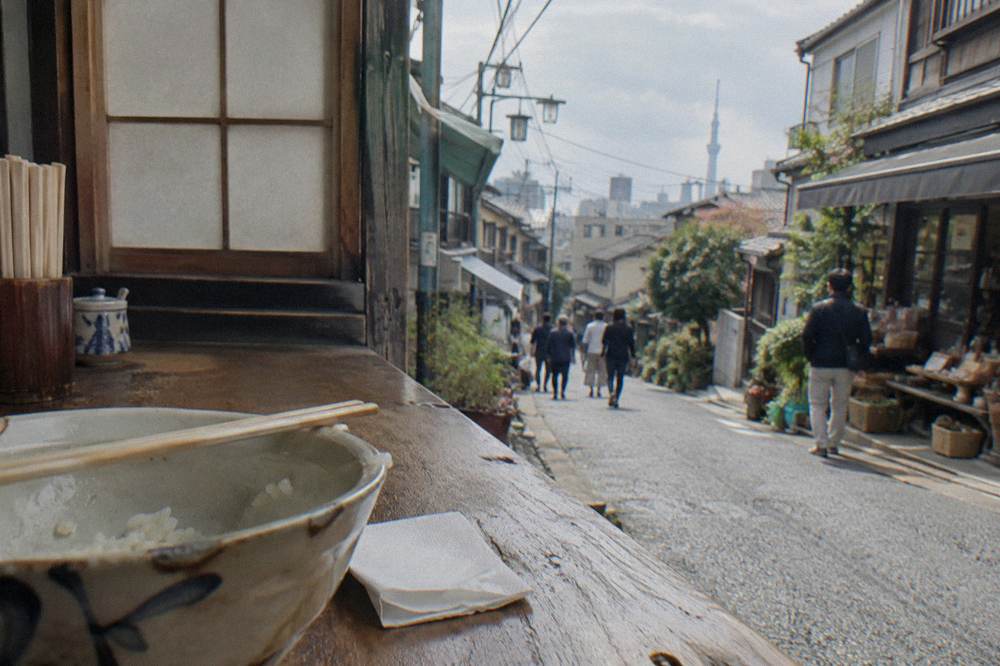 Wooden chopsticks resting across a small ceramic bowl on a wooden counter