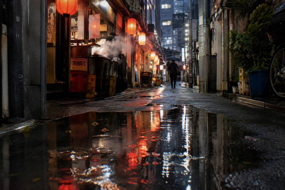 Narrow lantern-lit alley of small bars glowing at night in Shinjuku