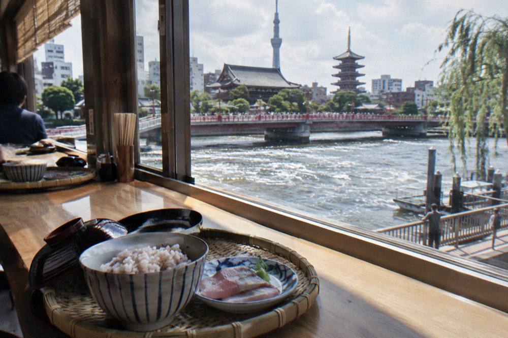 Bamboo rolling mats, bowls of vinegar rice and prepared fish laid along a bright classroom counter