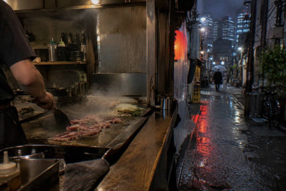 Thinly sliced marbled beef sizzling on a teppan griddle with steam rising