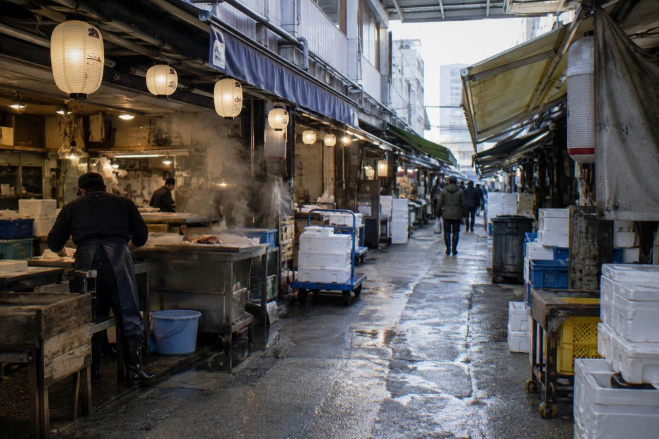 Narrow market lane in Tsukiji with shopfronts and hanging lanterns