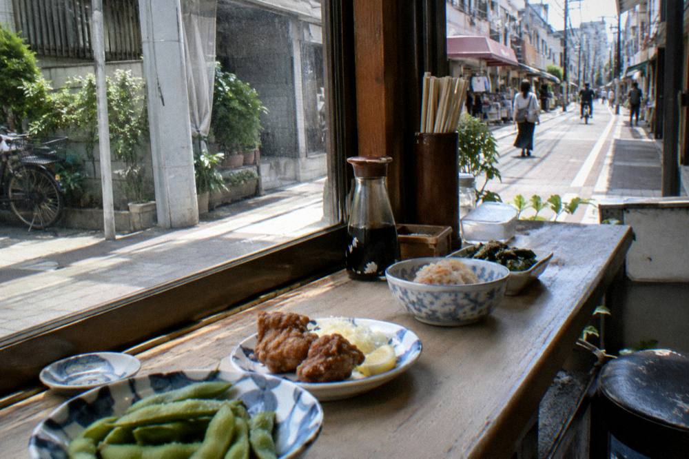 Assortment of Japanese snack dishes laid out along a wooden counter in a small eatery