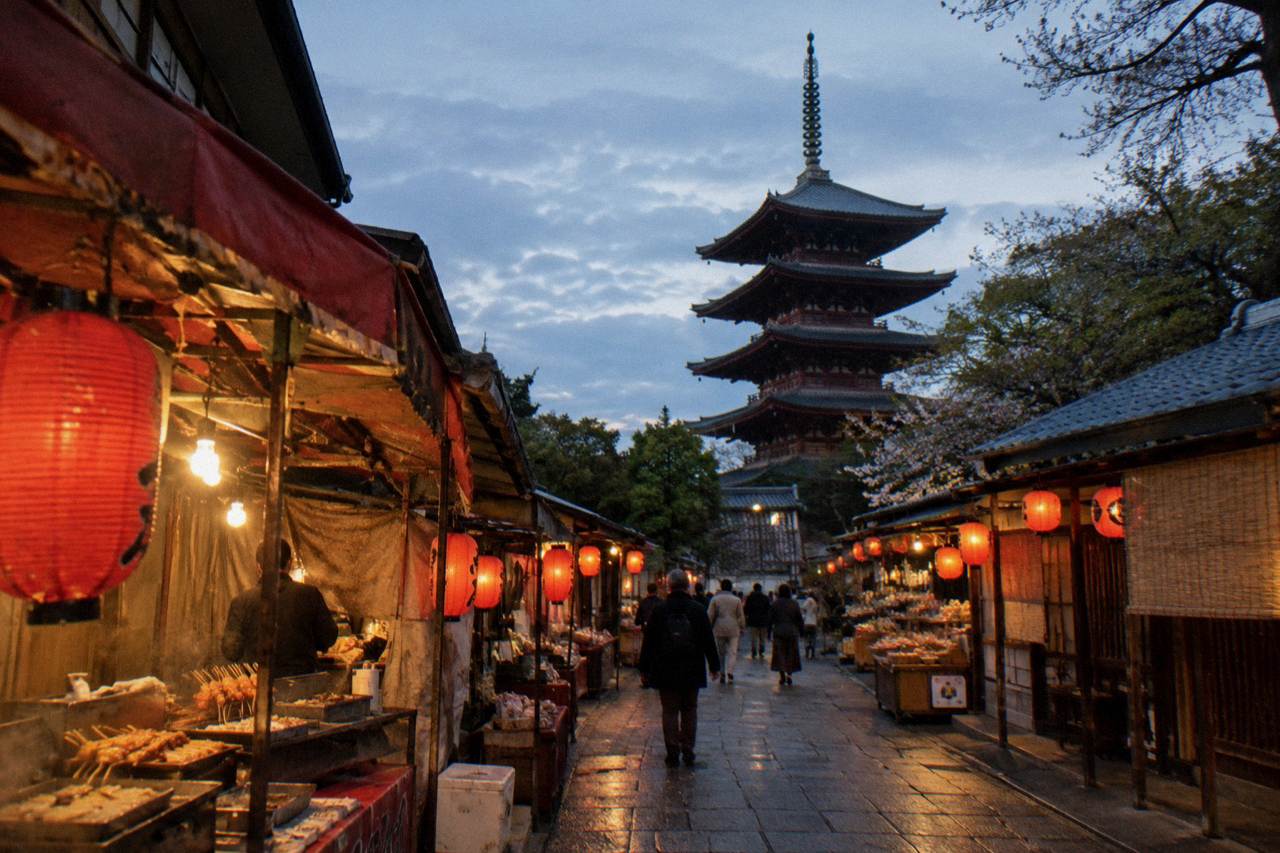 Lantern-lit shopping street in old Asakusa with food stalls on both sides at dusk